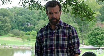 Movie still from “Mother's Day” (2016), directed by Garry Marshall – A man in a plaid shirt standing in front of a tree; Medium shot, Over the shoulder angle