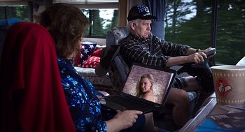Movie still from “Mother's Day” (2016), directed by Garry Marshall – An older man and woman sitting on a couch looking at a laptop; Medium shot, Over the shoulder angle