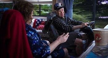 Movie still from “Mother's Day” (2016), directed by Garry Marshall – An older man and woman riding in a vehicle; Medium shot, Over the shoulder angle