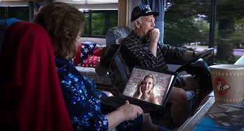Movie still from “Mother's Day” (2016), directed by Garry Marshall – An older man and woman sitting on a couch looking at a laptop; Medium shot, Over the shoulder angle