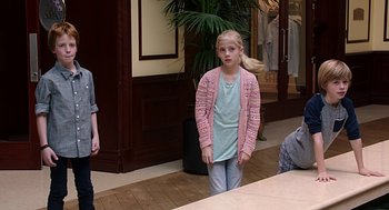 Movie still from “Mother's Day” (2016), directed by Garry Marshall – A young girl wearing a pink sweater standing in front of a mirror; Medium shot, Over the shoulder angle