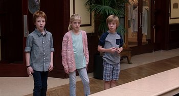 Movie still from “Mother's Day” (2016), directed by Garry Marshall – Three children standing in front of a mirror in a room; Medium shot, High angle