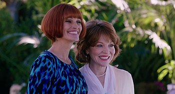 Movie still from “Mother's Day” (2016), directed by Garry Marshall – A couple of women standing next to each other in front of trees; Close Up shot, Low angle
