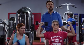 Movie still from “Mother's Day” (2016), directed by Garry Marshall – Two women and a man are in a gym; Medium shot, Over the shoulder angle