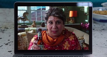 Movie still from “Mother's Day” (2016), directed by Garry Marshall – An older woman holding a bottle of beer in front of her face; Close Up shot, Over the shoulder angle