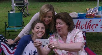 Movie still from “Mother's Day” (2016), directed by Garry Marshall – A group of people that are sitting in the grass; Close Up shot, High angle