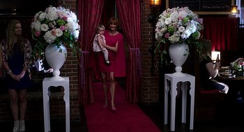 Movie still from “Mother's Day” (2016), directed by Garry Marshall – A woman holding a baby in a red dress; Wide shot, Over the shoulder angle