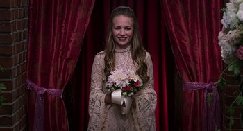 Movie still from “Mother's Day” (2016), directed by Garry Marshall – A young woman holding a bouquet of flowers; Medium shot, Over the shoulder angle