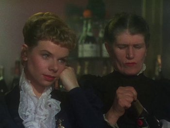 Movie still from “Moulin Rouge” (1952), directed by John Huston – Two women in a room with a bottle of wine; Close Up shot, Over the shoulder angle