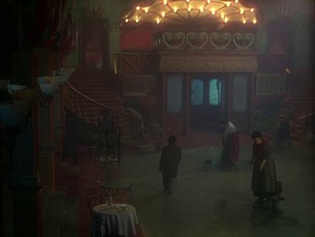 Movie still from “Moulin Rouge” (1952), directed by John Huston – A group of people standing in front of a building with lights on it; Extreme Wide shot, High angle
