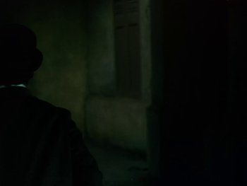 Movie still from “Moulin Rouge” (1952), directed by John Huston – A man standing in the dark in front of a building; Close Up shot, Low angle