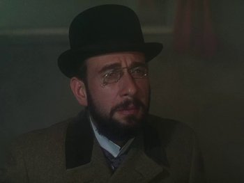Movie still from “Moulin Rouge” (1952), directed by John Huston – A man in a hat and glasses wearing a suit and hat; Close Up shot, Low angle