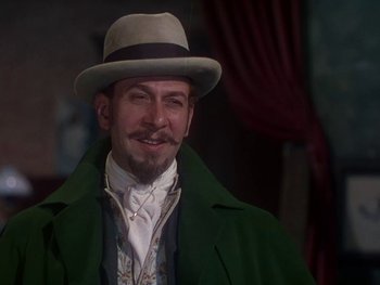Movie still from “Moulin Rouge” (1952), directed by John Huston – A man in a green coat and a gray hat; Medium shot, Low angle