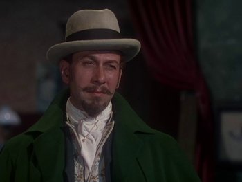 Movie still from “Moulin Rouge” (1952), directed by John Huston – A man with a beard wearing a green coat and a hat; Close Up shot, Low angle
