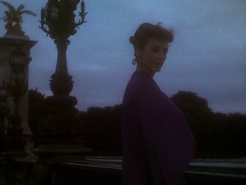 Movie still from “Moulin Rouge” (1952), directed by John Huston – A woman standing in front of an ornate light post; Medium shot, Low angle