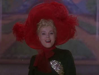 Movie still from “Moulin Rouge” (1952), directed by John Huston – A woman wearing a red hat and a sequined dress; Close Up shot, Low angle