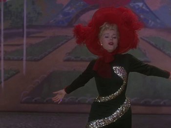 Movie still from “Moulin Rouge” (1952), directed by John Huston – A woman in a black dress and a red hat; Medium shot, Low angle