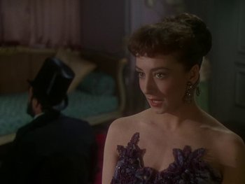 Movie still from “Moulin Rouge” (1952), directed by John Huston – A woman in a purple dress standing in front of a man; Close Up shot, Over the shoulder angle