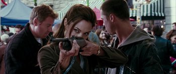Movie still from “Mr. & Mrs. Smith” (2005), directed by Doug Liman – A woman holding a gun while a man holds a camera; Close Up shot, Over the shoulder angle