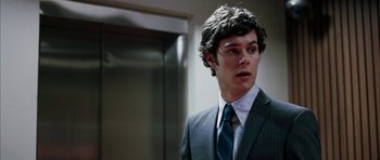 Movie still from “Mr. & Mrs. Smith” (2005), directed by Doug Liman – A man in a suit and tie standing in front of an elevator; Close Up shot, Over the shoulder angle
