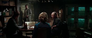 Movie still from “Mr. & Mrs. Smith” (2005), directed by Doug Liman – A group of people sitting around a table; Wide shot, Over the shoulder angle