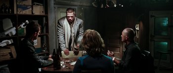 Movie still from “Mr. & Mrs. Smith” (2005), directed by Doug Liman – A group of people sitting around a table; Medium shot, Over the shoulder angle
