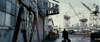 Movie still from “Mr. & Mrs. Smith” (2005), directed by Doug Liman – A man walking down a street near a building; Extreme Wide shot, Low angle