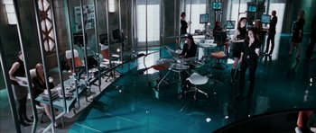 Movie still from “Mr. & Mrs. Smith” (2005), directed by Doug Liman – A man sitting at a table with a laptop in front of him; Wide shot, High angle