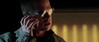 Movie still from “Mr. & Mrs. Smith” (2005), directed by Doug Liman – A man wearing glasses talking on a cell phone; Close Up shot, Low angle