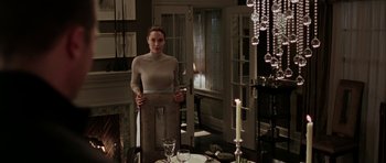 Movie still from “Mr. & Mrs. Smith” (2005), directed by Doug Liman – A woman standing in front of a dining room table; Medium shot, Low angle