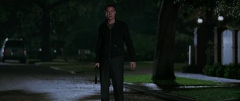 Movie still from “Mr. & Mrs. Smith” (2005), directed by Doug Liman – A man holding a gun while standing in the dark; Wide shot, Low angle