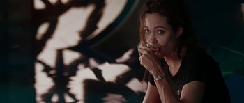 Movie still from “Mr. & Mrs. Smith” (2005), directed by Doug Liman – A woman sitting in front of a mirror drinking a beverage; Medium shot, High angle