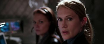Movie still from “Mr. & Mrs. Smith” (2005), directed by Doug Liman – Two women wearing headsets looking at the camera; Close Up shot, Over the shoulder angle
