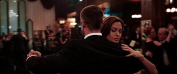 Movie still from “Mr. & Mrs. Smith” (2005), directed by Doug Liman – A man and a woman are hugging in front of a crowd of onlookers; Close Up shot, Over the shoulder angle