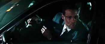 Movie still from “Mr. & Mrs. Smith” (2005), directed by Doug Liman – A man sitting in the driver's seat of a car at night; Close Up shot, Over the shoulder angle