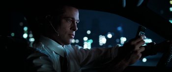 Movie still from “Mr. & Mrs. Smith” (2005), directed by Doug Liman – A man sitting in the drivers seat of a car at night; Close Up shot, Low angle