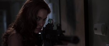 Movie still from “Mr. & Mrs. Smith” (2005), directed by Doug Liman – A beautiful woman holding a gun in a dark room; Close Up shot, Over the shoulder angle