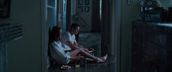 Movie still from “Mr. & Mrs. Smith” (2005), directed by Doug Liman – A man and a woman sitting on the floor in a room; Wide shot, High angle