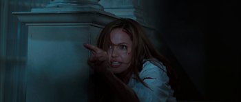 Movie still from “Mr. & Mrs. Smith” (2005), directed by Doug Liman – A woman with blood all over her face is pointing to the side; Close Up shot, Low angle