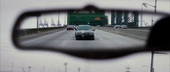 Movie still from “Mr. & Mrs. Smith” (2005), directed by Doug Liman – A car is seen through a car's windshield wiper; Close Up shot, Over the shoulder angle