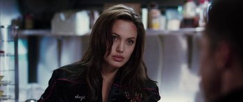 Movie still from “Mr. & Mrs. Smith” (2005), directed by Doug Liman – A woman with long dark brown hair wearing a black jacket; Close Up shot, Over the shoulder angle