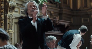 Movie still from “Mr. Bean's Holiday” (2007), directed by Steve Bendelack – An older man in a black suit and white shirt; Medium shot, Low angle