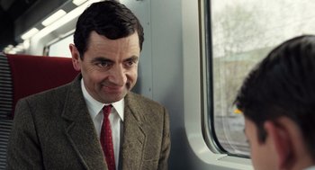 Movie still from “Mr. Bean's Holiday” (2007), directed by Steve Bendelack – A person sitting on a train; Close Up shot, Over the shoulder angle