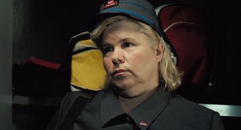 Movie still from “Mr. Bean's Holiday” (2007), directed by Steve Bendelack – A woman wearing a hat sitting in front of a backpack; Close Up shot, High angle