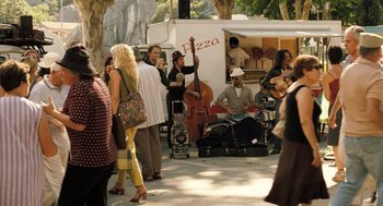 Movie still from “Mr. Bean's Holiday” (2007), directed by Steve Bendelack – A group of people that are standing in the street; Wide shot, Over the shoulder angle