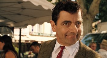 Movie still from “Mr. Bean's Holiday” (2007), directed by Steve Bendelack – A person wearing a suit and a tie; Close Up shot, Over the shoulder angle