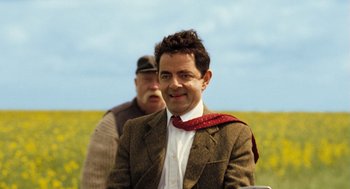 Movie still from “Mr. Bean's Holiday” (2007), directed by Steve Bendelack – A man wearing a suit and a red neck tie; Close Up shot, Low angle