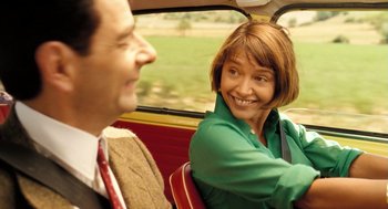 Movie still from “Mr. Bean's Holiday” (2007), directed by Steve Bendelack – A man and a woman in the back seat of a car; Close Up shot, Over the shoulder angle