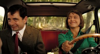 Movie still from “Mr. Bean's Holiday” (2007), directed by Steve Bendelack – Two people sitting in the back seat of a car; Medium shot, High angle