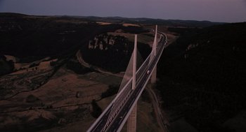 Movie still from “Mr. Bean's Holiday” (2007), directed by Steve Bendelack – An aerial view of a bridge at night with cars on it; Extreme Wide shot, High angle